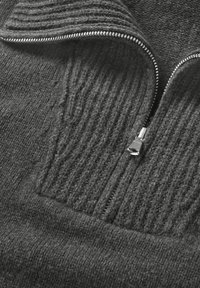 Dunkelgrauer Zip-Pullover aus strukturiertem Strickstoff, mit gerippten Details auf der Brust und einem silbernen Metallreißverschluss.