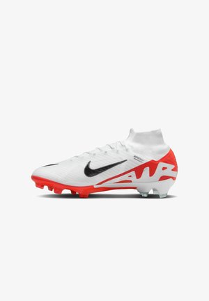 Nike Fußballschuh mit weißem, strukturiertem Obermaterial, roter Sohle, schwarzem Swoosh und markanten roten Akzenten. Verfügt über ein hohes Knöcheldesign und Nockenlaufsohle.