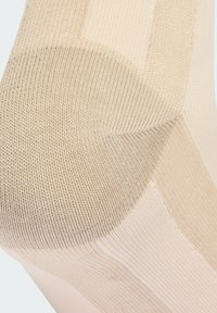 Beżowa skarpetka do kostki z teksturowanym wzorem dzianiny, ściągaczem u góry, gładkim szwem na palcach oraz wzmocnionym obszarem pięty dla trwałości.