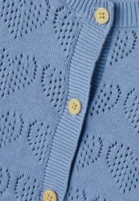 Hele sinine kootud kardigan tekstuurse südamemustriga, millel on nööbitav sulgemisdetail ja soonikuga krae. Sile, pehme kangapind.