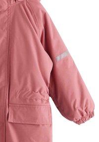 Giacca impermeabile rosa con texture liscia, polsini elastici, tasche frontali e una striscia riflettente sulla manica.