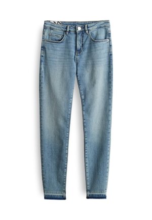 Jean en denim bleu clair avec une coupe fuselée, cinq poches, une fermeture à bouton et des coutures sur les bords.