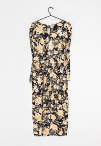 Robe noire à manches longues avec un motif floral jaune et rose, taille froncée et décolleté en forme de goutte, suspendue sur un cintre noir contre un fond blanc.