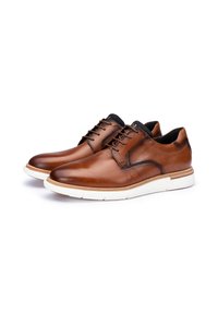 Scarpe eleganti in pelle marrone con una texture liscia, suola bianca e dettagli interni neri. Presentano lacci tradizionali e un design elegante.