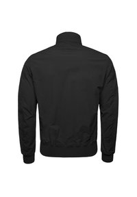 Musta pommikauppatakki, jossa on korkea kaulus, ribbikuvioidut hihansuut ja vyötärö. Sileä, kevyt kangas, jossa on yksinkertainen, koristamaton muotoilu.