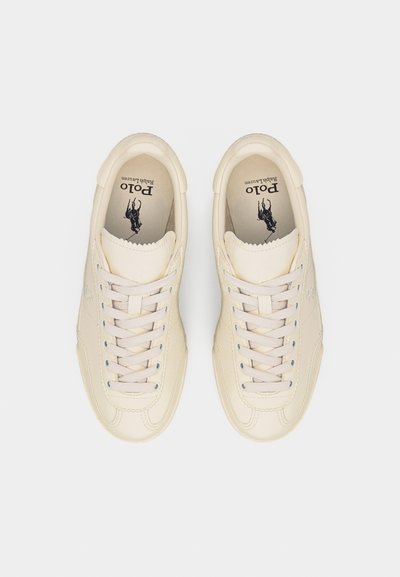 Ζευγάρι μπεζ αθλητικά παπούτσια Polo Ralph Lauren με κορδόνια, φωτογραφημένα από πάνω σε λευκό φόντο.