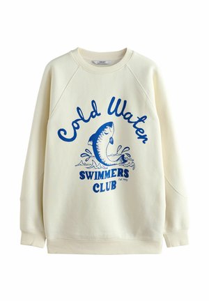 Kremowy sweatshirt z rękawami raglanowymi, z niebieską grafiką ryby i tekstem "Klub Pływaków w Zimnej Wodzie" napisanym pogrubioną czcionką.
