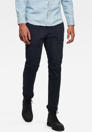 Ciemnogranatowe chinosy wykonane z mieszanki bawełny. Charakteryzują się dopasowanym krojem, podwiniętymi mankietami oraz gładką fakturą. Połączone z czarnymi botkami na sznurowadła.