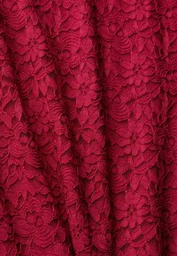 Tissu en dentelle bourgogne avec un motif floral et des détails texturés ; design délicat et complexe sur l'ensemble du matériau.