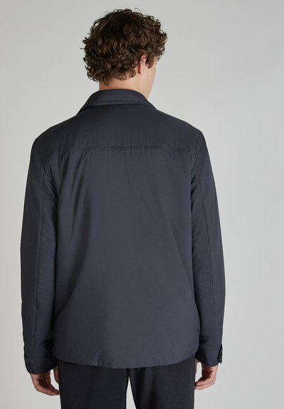 Granatowa, lekka kurtka o gładkiej fakturze, z kołnierzem i mankietami zapinanymi na guziki, charakteryzująca się prostym, czystym krojem bez widocznych wzorów.