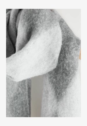 Zachte, dikke sjaal met een vlezige textuur in afwisselend licht en donkergrijs, losjes gehangen aan een houten hanger.