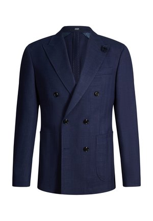 Granatowa marynarka dwurzędowa z sześcioma czarnymi guzikami, klapami z wycięciem, dwoma przednimi kieszeniami i małą kwiatową przypinką na klapie.