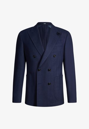Blazer doppiopetto blu navy con sei bottoni neri, revers a intaglio, due tasche frontali e una piccola spilla floreale sul rever.