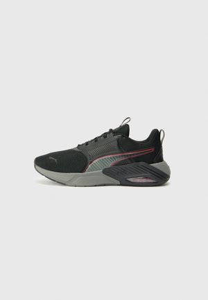 Zwarte sportschoenen met mesh- en rubberpanelen, grijze zool, roze accenten en een gestructureerd design. Bevat een gevoerde hak en vetersluiting.