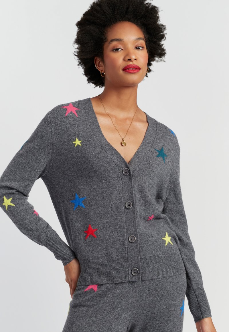 Grijze cardigan met een V-hals, voorzien van kleurrijke ster applicaties in roze, geel, blauw en rood. Knopen sluiting en ribgebreide manchetten.