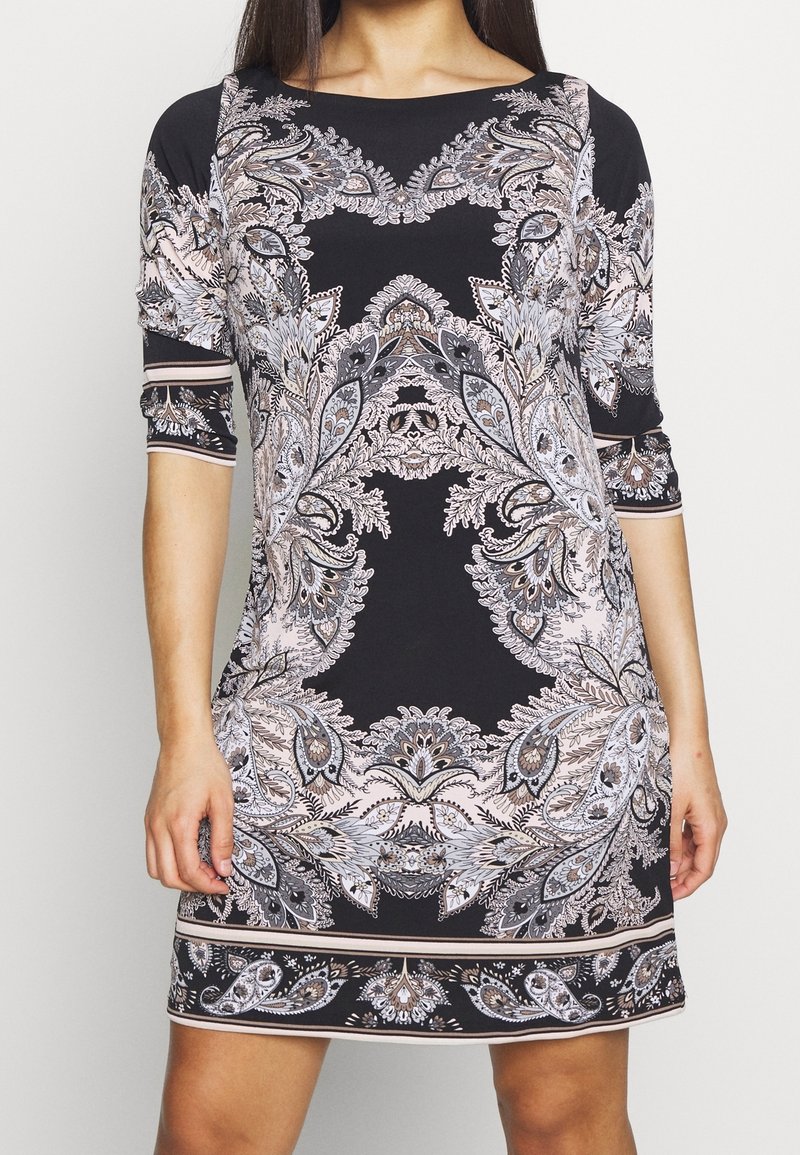 Černé šaty s propracovanými paisley vzory v světle růžové, šedé a stříbrné. Rukávy tři čtvrtiny a rovný, přiléhavý střih.