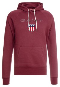 Sudadera capucha color burdeos con un bolsillo delantero tipo pouch, cordón y logo bordado de escudo en colores rojo, blanco y azul.
