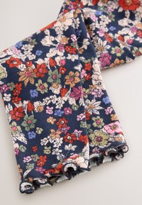 Blommigt manchestertyg med marinblå bakgrund, prytt med mångfärgade blommor i rosa, rött, gult och grönt. Volangkanter ger extra textur.