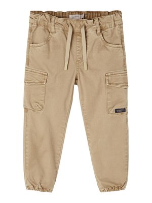 Pantalons cargo beiges avec une taille élastique et un cordon de serrage, comportant des poches latérales et des poignets élastiques aux chevilles. Tissu en coton lisse.