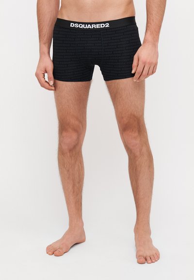 Černé boxerky vyrobené z měkké tkaniny, s celoplošným vzorem loga DSQUARED2. Pas je elastický s kontrastním značkovým štítkem.