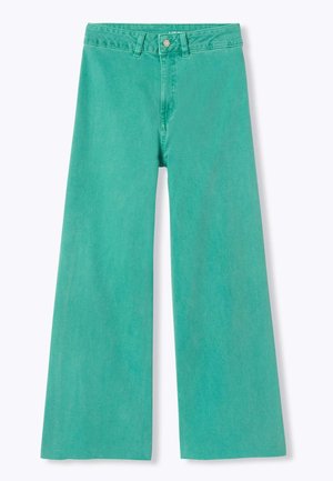 Jean vert taille haute à jambes larges avec passants de ceinture, fermeture par bouton et coutures visibles à l’avant sur fond blanc.