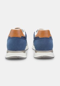 Blue suede sneakers with brown leather heel accents, white soles, and gray details. Features cushioned back and textured surfaces.