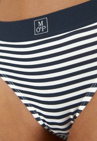 Randig bikinitop i marinblått och vitt, med mjuk tyg, smal skärning och ett elastiskt midjeband med en liten logotagg.