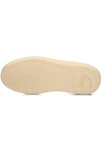 Suola in gomma di colore beige chiaro con una superficie texturizzata, caratterizzata da una sottile impronta del logo su un lato. Forma liscia e arrotondata.