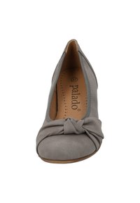 Escarpin en daim gris avec un détail noué au bout, texture douce, forme arrondie et petit talon. L'intérieur est doté d'un rembourrage perforé.