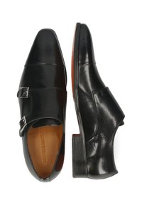 Scarpe di pelle nera con design a punta, dettaglio a doppia fibbia, texture liscia e tacco in legno basso.