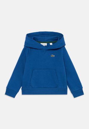 Blå bomullshoodie med kengurulomme, ribbestrikkede mansjetter og kant, samt en liten grønn brodert logo på brystet.