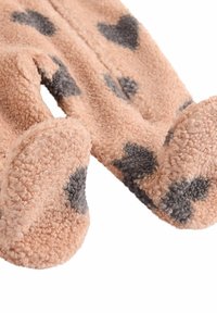 Ljust rosa fleece-strumpor med en mjuk textur, prydda med mörkgrå hjärtformade mönster. Sålarnas form är rundad och mjuk, vilket ger värme.