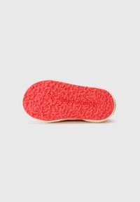 Suola di scarpa in gomma con un motivo testurizzato, rosso brillante, caratterizzato da un design a presa rialzata e bordo beige neutro. Marchio "Superga" sul lato.