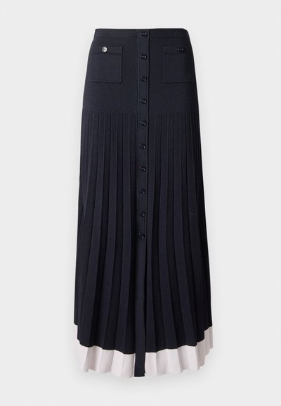 Plissé maxi rok in donker marineblauw met knoopsluiting. Voorzien van twee voorzakken en een lichtgekleurde zoom. Gemaakt van een zachte, gestructureerde stof.