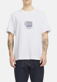 Camiseta de algodón blanca con un diseño gráfico azul de un edificio y el texto "WILLIAMSBURG", de mangas cortas y un corte relajado.