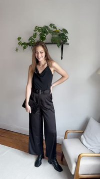 Zwarte coltrui gecombineerd met hoge taille zwarte wijde broek en zwarte enkellaarsjes met hakken, aangevuld met een zwarte textuur clutch.