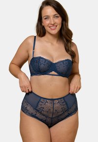 Ensemble de lingerie composé d'un soutien-gorge en dentelle bleu marine et d'une culotte taille haute, ornés de motifs floraux, de panneaux en tulle transparent, de bretelles réglables et de bords festonnés.