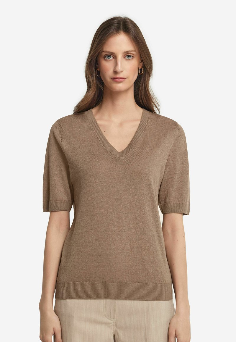 Lys brun kortærmet sweater med V-hals, ribbet kant og glat tekstur. Enkel design uden mønstre eller pynt.