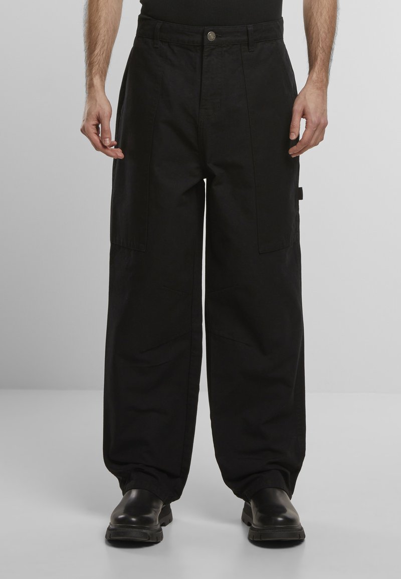 Fekete cargo nadrág széles lábakkal, két nagy oldalsó zsebbel, ötkapcsolós záródással és sima szövet textúrával.