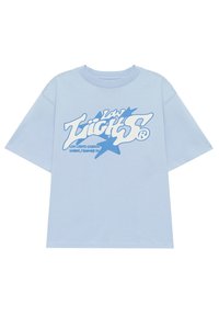 Camiseta de algodón azul claro con mangas cortas. Presenta un gran logotipo gráfico blanco y texto en azul contrastante, centrado en la parte delantera.