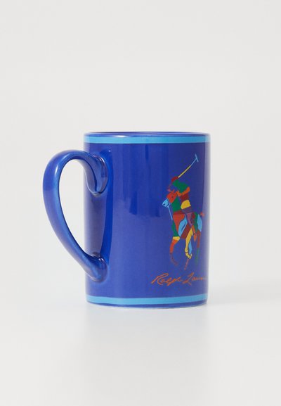 Zila keramikas krūze ar izliekto rokturi, uz kuras attēlots krāsains polo spēlētāja grafiks un uzraksts „Ralph Lauren” oranžā krāsā.