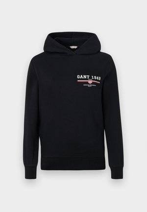 Black hoodie made of cotton with a logo featuring "GANT 1949" and striped accents in red and white on the front. Standard fit with a drawstring hood.
