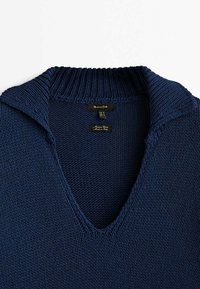 Marineblaue Strickjacke mit V-Ausschnitt und geripptem Kragen. Verfügt über ein strukturiertes Muster und Etiketten, die Marke und Herkunft angeben.