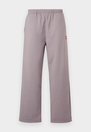 Pantalones deportivos de pierna ancha en tonos púrpura claro, con cintura elástica y pequeña etiqueta de logo rojo en la costura lateral.