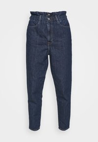 Mörkblå denimbyxor med elastisk midja, två framfickor och en avsmalnande benlinje. Tyget har en slät textur med subtila sömmar.