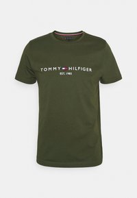 Olivegrünes Baumwoll-T-Shirt mit Rundhalsausschnitt und kurzen Ärmeln, mit weißem "TOMMY HILFIGER"-Logo und dem Text "EST. 1985".