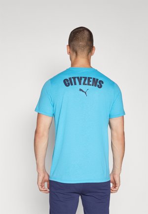 Puma blå t-shirt med korte ærmer, der har teksten "CITYZENS" med fed sort skrift på ryggen og Puma-logoet under.
