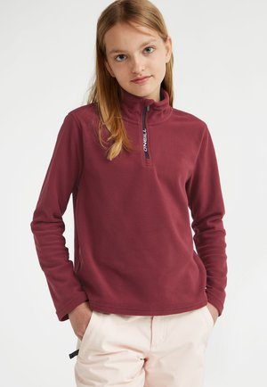 Pull en polaire bordeaux avec un col haut, un encolure zippée et des manches longues. Présente un logo le long de la fermeture éclair. Texture douce et design simple.
