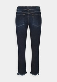 Vaqueros de mezclilla azul oscuro con un dobladillo ligeramente desgastado, que presentan bolsillos traseros y un diseño de pierna recta. Bordes deshilachados en el tobillo.
