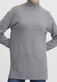 Maglione grigio a collo alto in morbido tessuto a maglia, con maniche lunghe e collo e orlo a coste. Dettaglio logo discreto sul lato sinistro in basso.